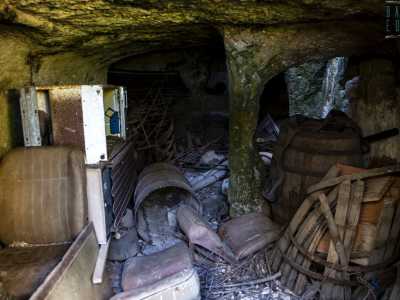 L�interno sembra una vera e propria discarica, tra antiche botti, un frigorifero, ferraglia e boccioni di vetro risulta difficile anche camminare